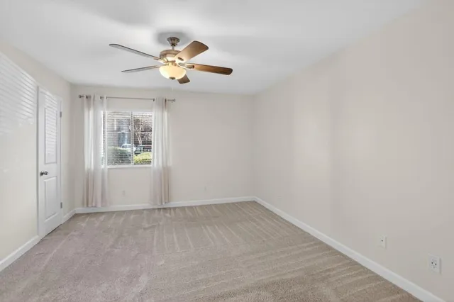 a view of a livingroom with a ceiling fan and window