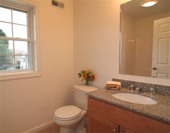 6 Blue Jay Circle, Unit 2 Wakefield, MA 01880 - Photo 15 of 17 a bathroom with a granite countertop toilet a sink and a mirror