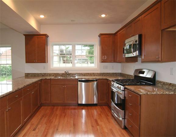 6 Blue Jay Circle, Unit 2 Wakefield, MA 01880 - Photo 10 of 17 a kitchen with stainless steel appliances granite countertop wooden cabinets stove top oven and sink