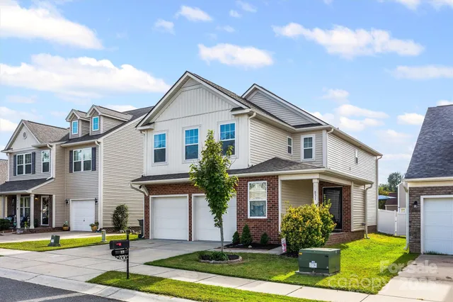 a front view of a residential houses with yard and tress