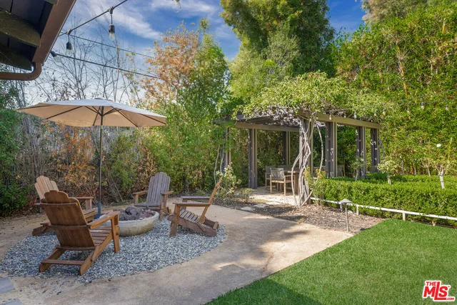a view of a patio with table and chairs under an umbrella
