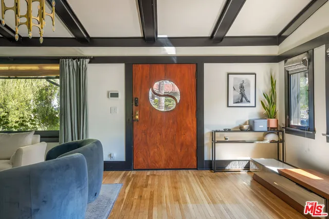 a view of a hallway with wooden floor and a cabinet