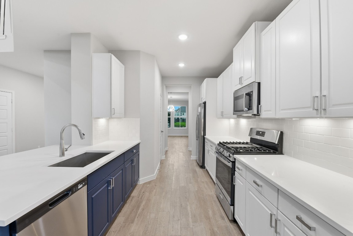 2415 Inlet Court Fresno, TX 77545 - Photo 16 of 50 a kitchen with sink a stove and cabinets