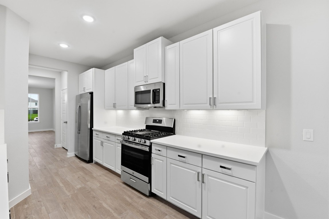 2415 Inlet Court Fresno, TX 77545 - Photo 17 of 50 a kitchen with white cabinets and stainless steel appliances