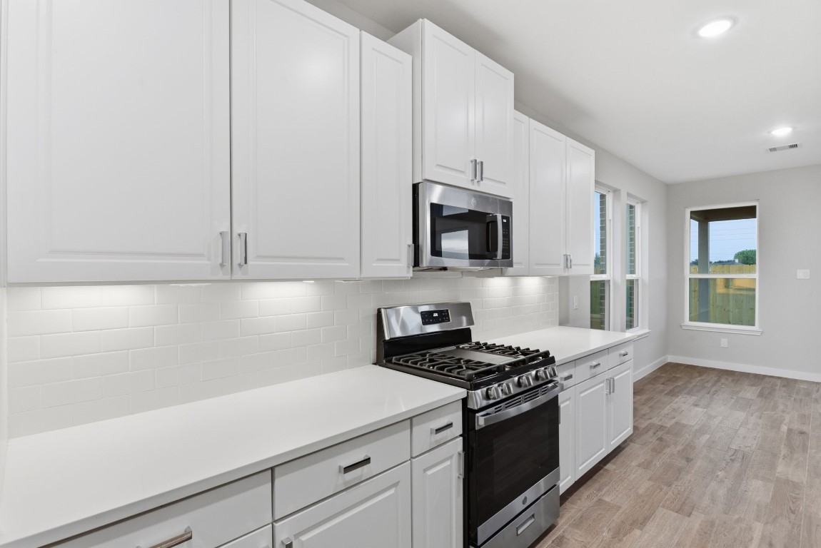 2415 Inlet Court Fresno, TX 77545 - Photo 19 of 50 a kitchen with granite countertop white cabinets and stainless steel appliances