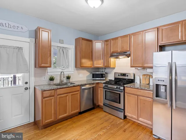 a kitchen with stainless steel appliances granite countertop a stove a sink dishwasher and a refrigerator