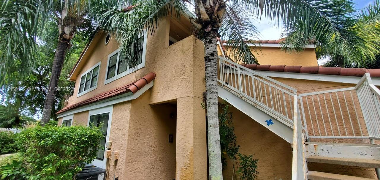 15661 Southwest 104th Terrace, Unit 321 Miami, FL 33196 - Photo 3 of 21 a view of a house with a tree and wooden fence