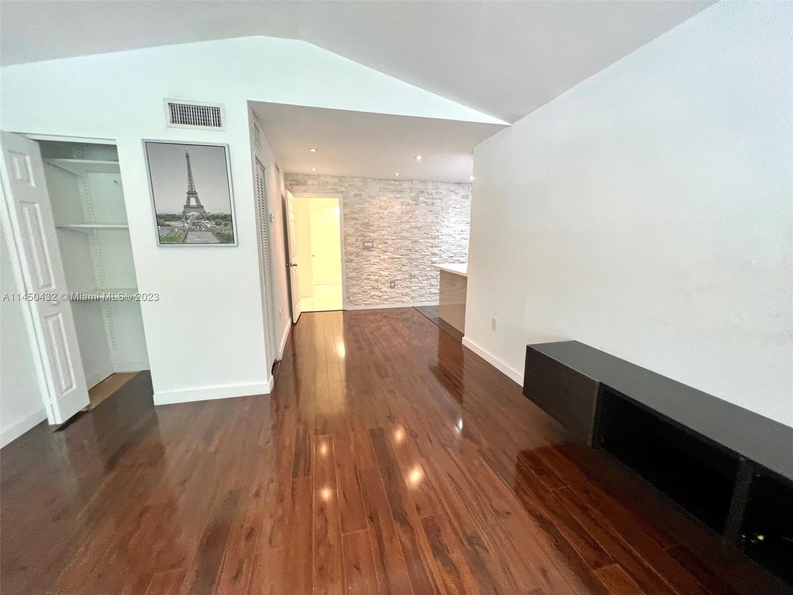 15661 Southwest 104th Terrace, Unit 321 Miami, FL 33196 - Photo 6 of 21 a view of an empty room with wooden floor and a window