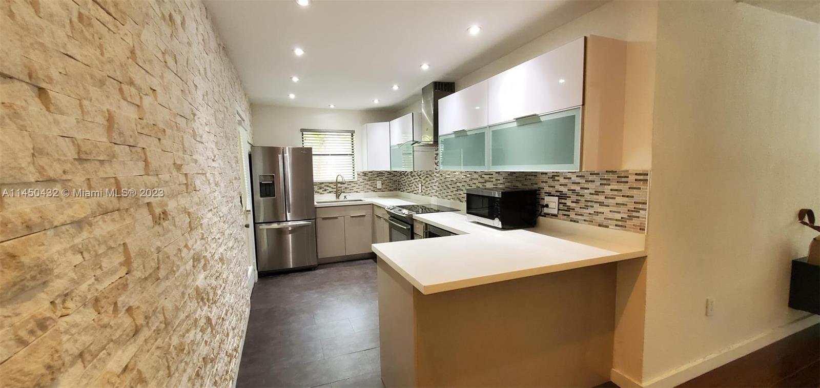15661 Southwest 104th Terrace, Unit 321 Miami, FL 33196 - Photo 10 of 21 a kitchen with stainless steel appliances a refrigerator a sink a stove top oven with wooden floor