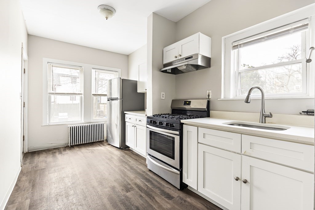 a kitchen with stainless steel appliances a white stove top oven and a large window