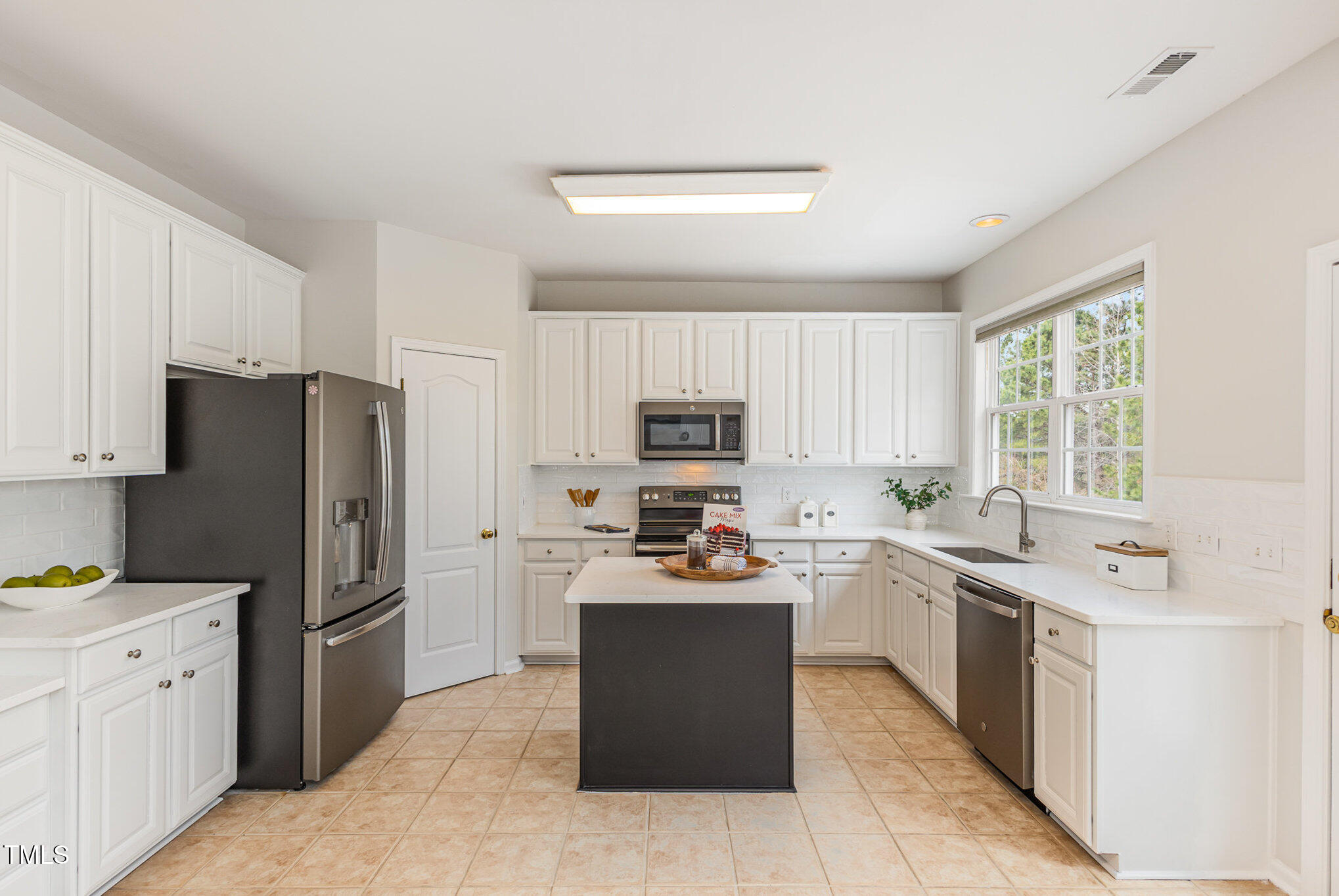 7533 Silver View Lane Raleigh, NC 27613 - Photo 7 of 25 a kitchen with stainless steel appliances a stove sink refrigerator and cabinets