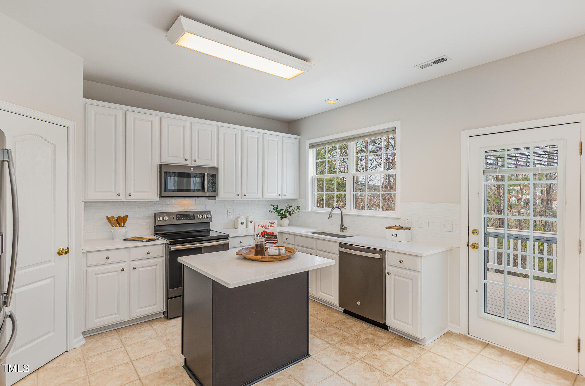 7533 Silver View Lane Raleigh, NC 27613 - Photo 8 of 25 a kitchen with stainless steel appliances a stove sink microwave and cabinets