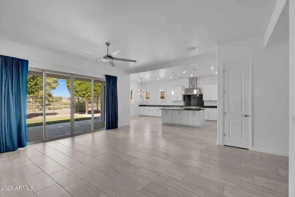 a large kitchen with stainless steel appliances a large counter top a stove a sink and a refrigerator