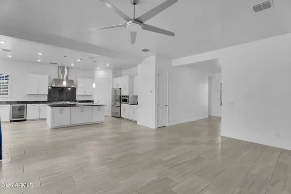 a large kitchen with stainless steel appliances granite countertop a stove a sink dishwasher and a oven with white cabinets