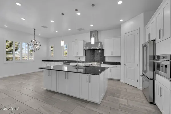 a kitchen with stainless steel appliances granite countertop a sink stove and refrigerator