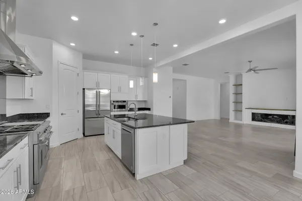 a kitchen with stainless steel appliances granite countertop a stove refrigerator sink and microwave