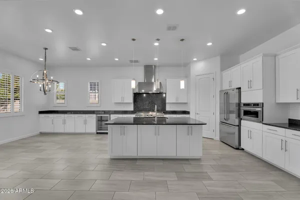 a kitchen with stainless steel appliances granite countertop a stove a sink and a refrigerator