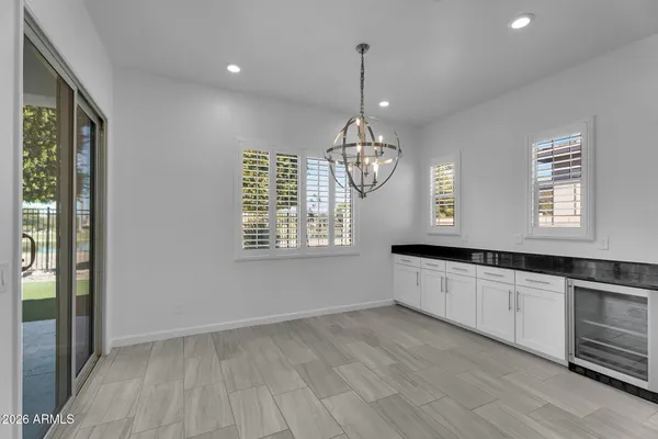 an empty room with ceiling fan and windows