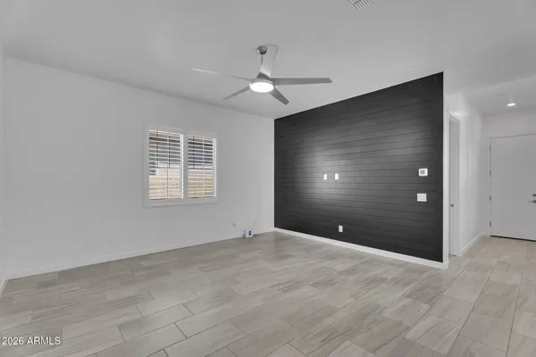 an empty room with windows and fan