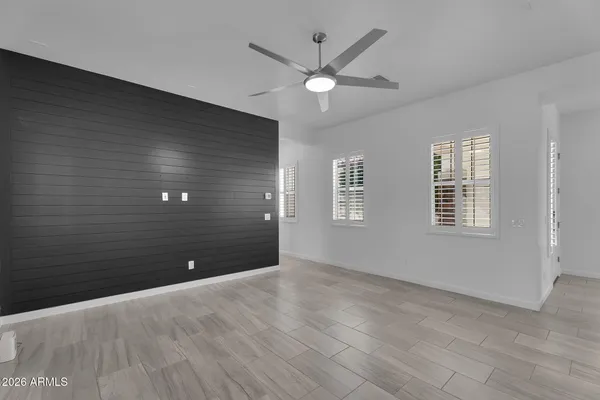an empty room with a ceiling fan and windows