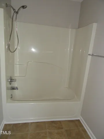 a bathroom with a bath tub with a shower