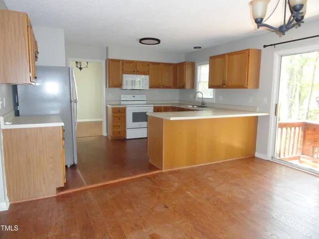 a large kitchen with stainless steel appliances granite countertop a stove a sink and a refrigerator