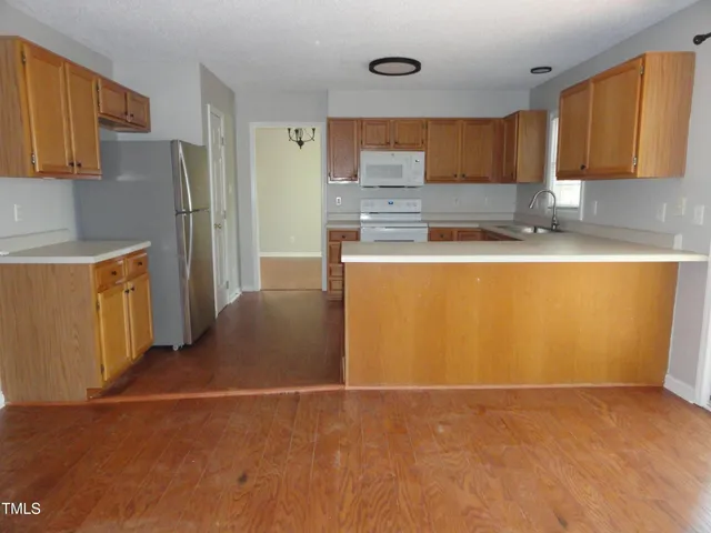 a kitchen with stainless steel appliances a refrigerator a stove top oven a sink and dishwasher