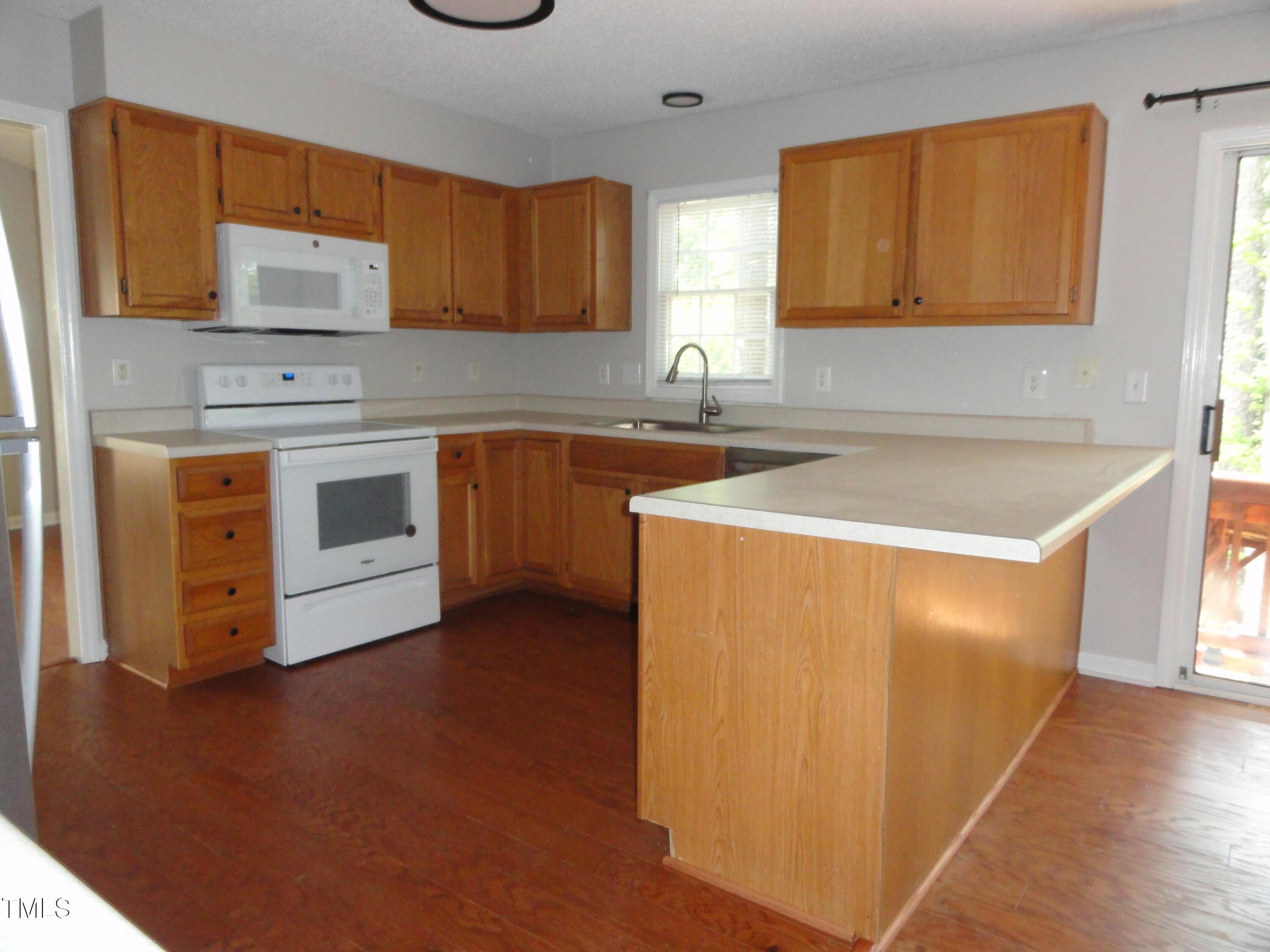 201 Union Mills Way Cary, NC 27519 - Photo 5 of 15 a kitchen with stainless steel appliances granite countertop a sink and a stove with wooden floor
