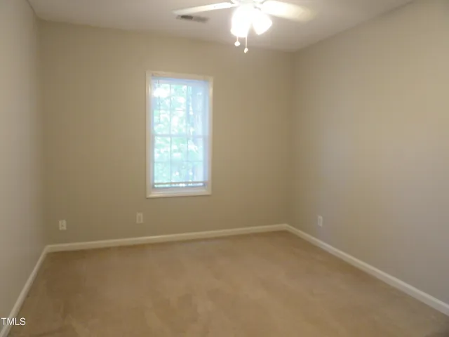en empty room with windows and chandelier fan