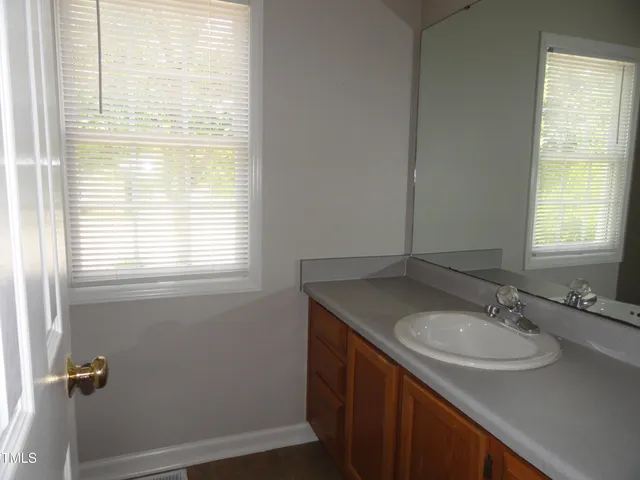 a bathroom with a sink a vanity and a window