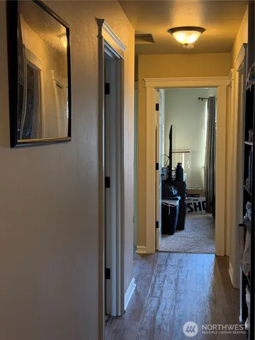 a view of a hallway with a livingroom and furniture