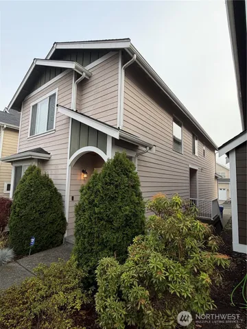 a front view of a house with plants and garage