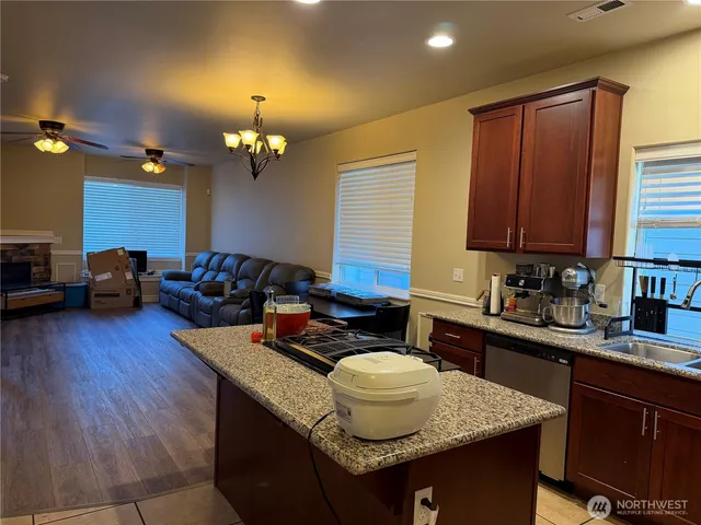 a kitchen with a granite countertop sink stove and cabinets