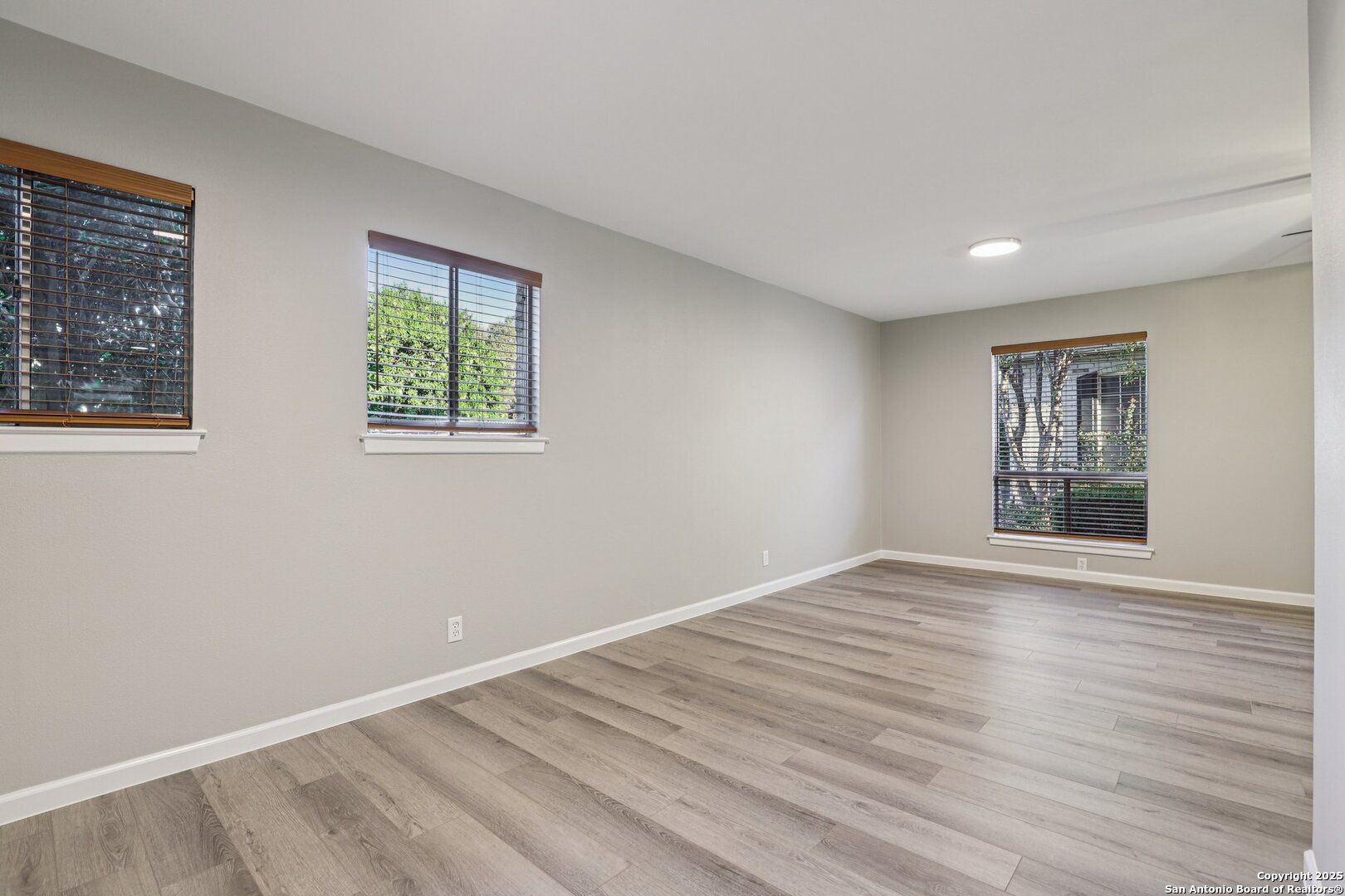 3441 Turtle Village Drive, Unit 92FF San Antonio, TX 78230 - Photo 12 of 34 a view of an empty room with wooden floor and a window