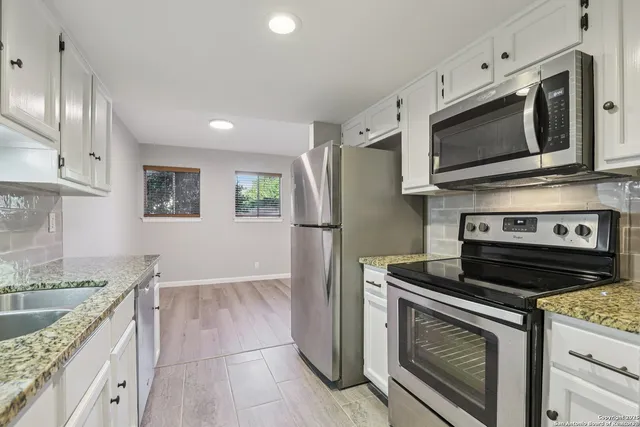 a kitchen with stainless steel appliances granite countertop a stove microwave and refrigerator