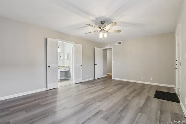 a view of an empty room with wooden floor