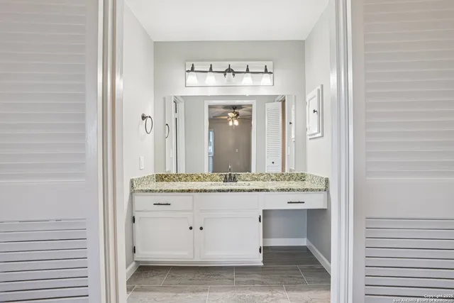 a bathroom with a granite countertop sink and a mirror