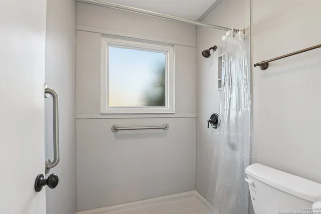 a bathroom with a toilet a sink and shower