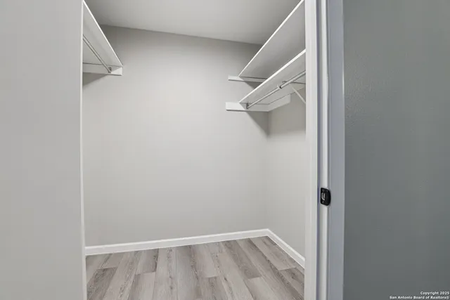 a view of walk in closet with empty racks