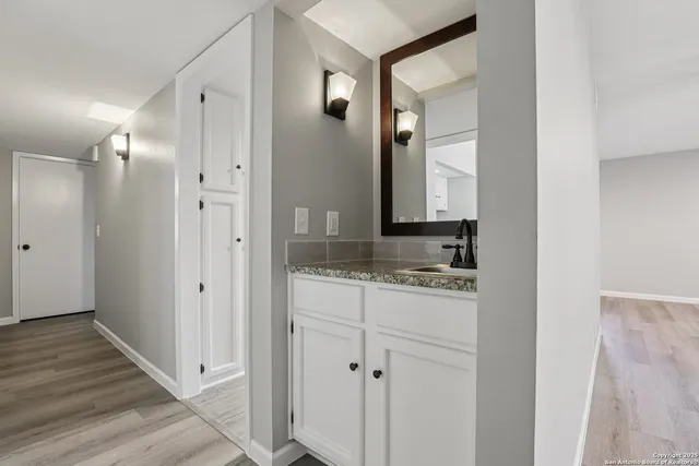 a bathroom with a granite countertop sink and a mirror