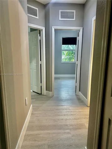 a view of a hallway with wooden floor and a hallway