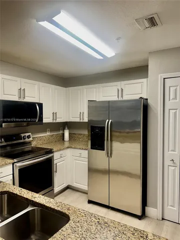 a kitchen with a sink stainless steel appliances and cabinets