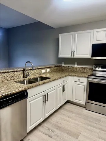a kitchen with granite countertop a sink and cabinets