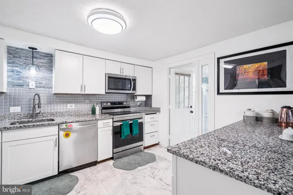 a kitchen with a sink stove and cabinets