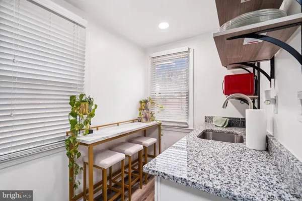 a kitchen with a granite countertop kitchen island with stainless steel appliances granite countertop stove top oven and cabinets