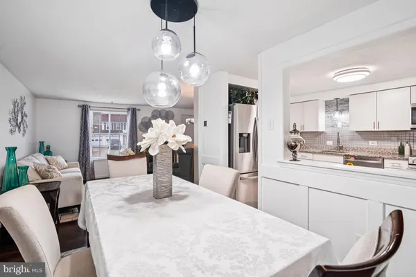 a kitchen with stainless steel appliances kitchen island granite countertop a sink a refrigerator and chandelier