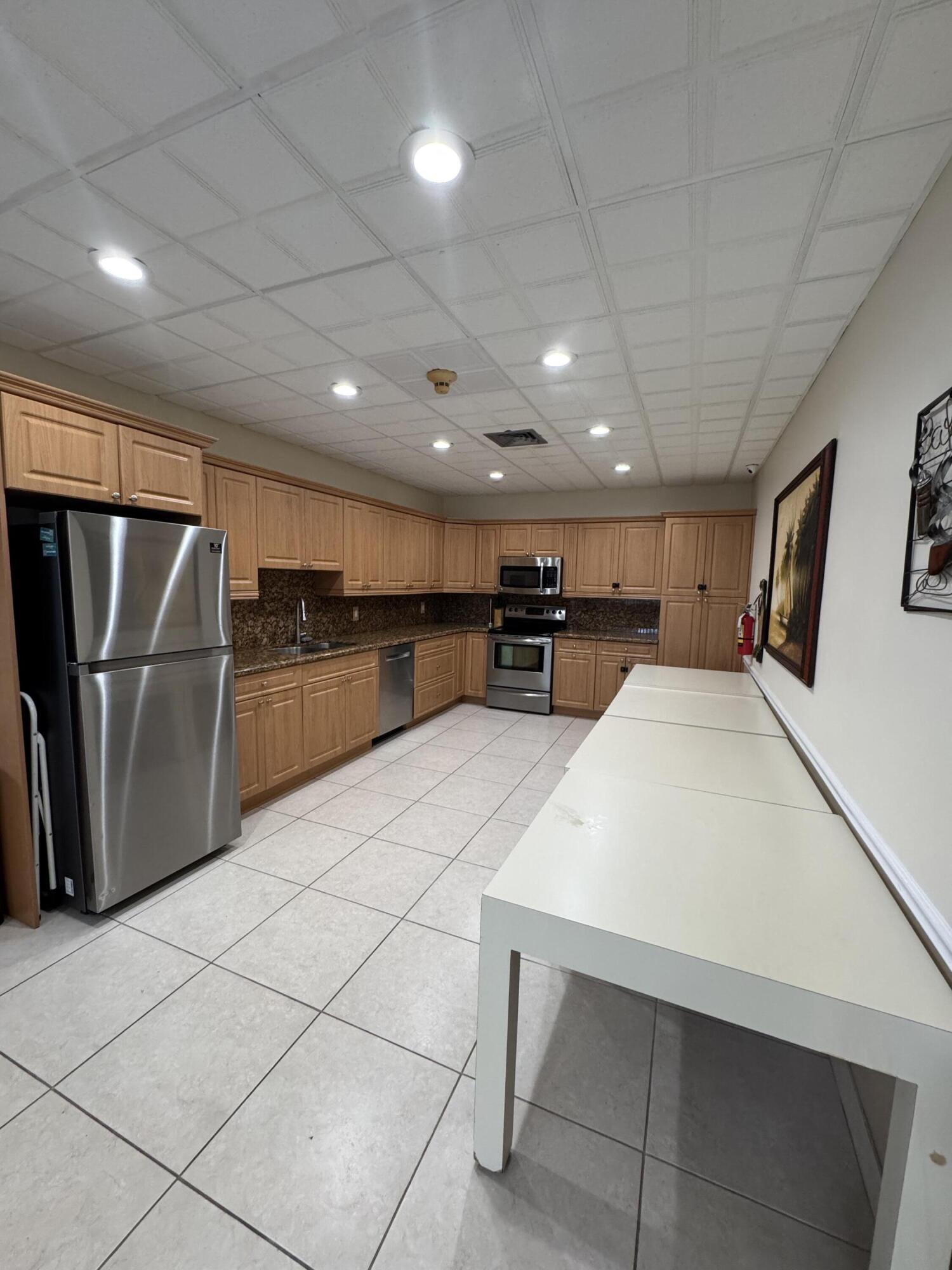 336 Golfview Road, Unit 706 North Palm Beach, FL 33408 - Photo 32 of 41 a large white kitchen with wooden floor and a refrigerator in a kitchen