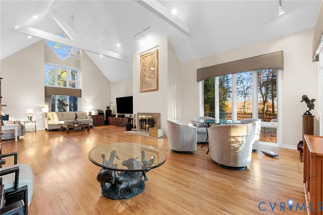 a dining room with furniture large windows and a chandelier