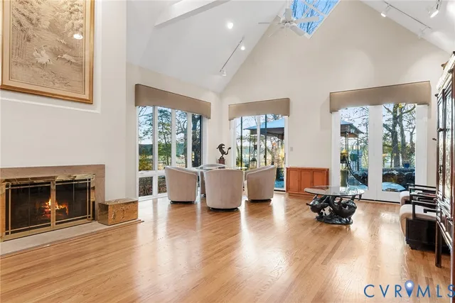 a dining room with furniture large windows and a chandelier