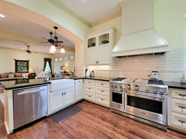 a kitchen with granite countertop a sink stainless steel appliances and counter space